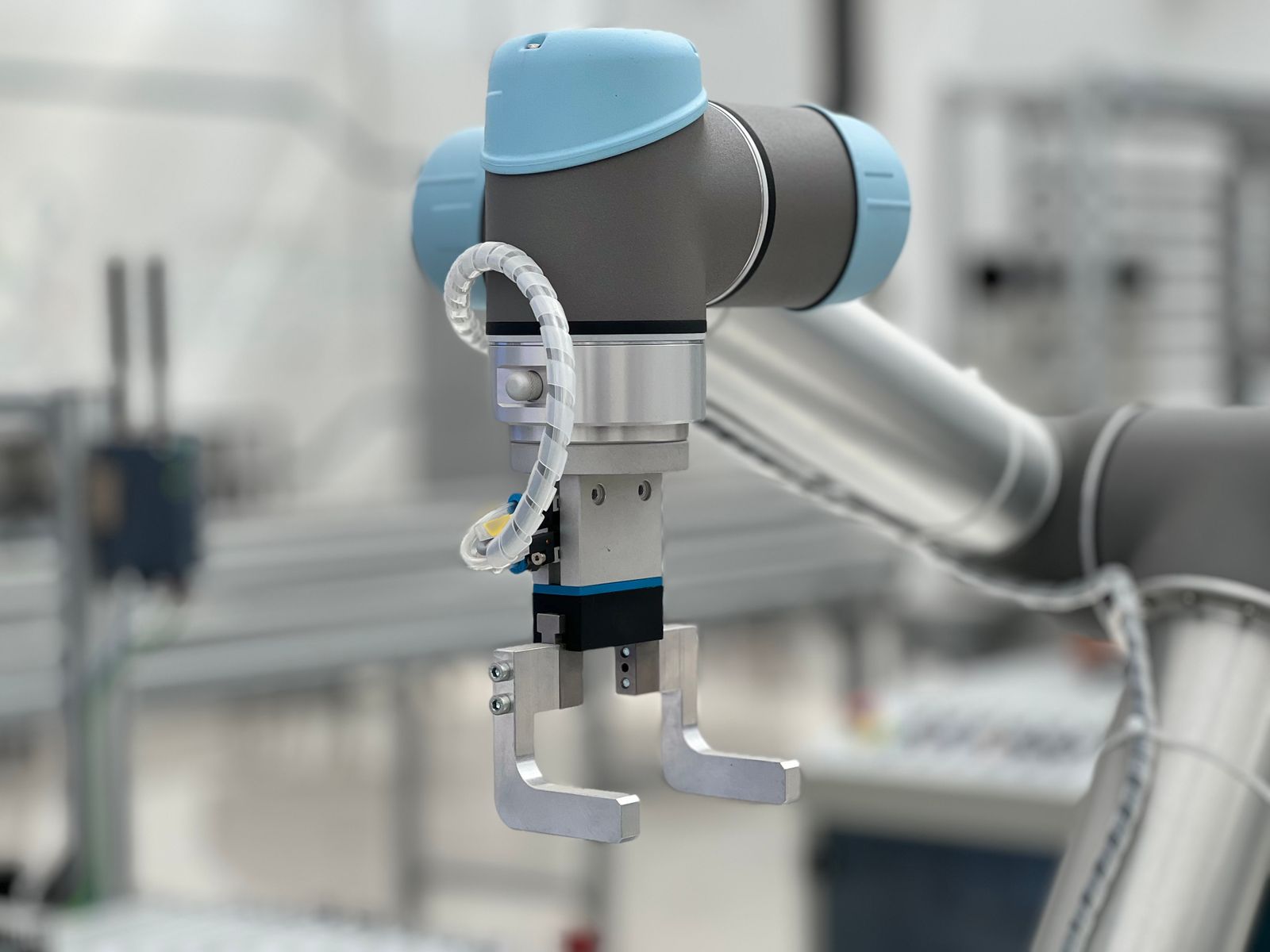 Nahaufnahme eines modernen Roboterarms mit Greifer in einer Produktionsumgebung